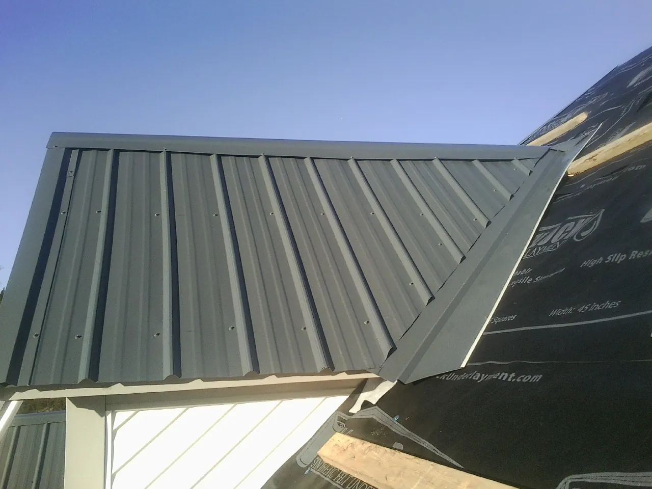Gray metal roof panels going on over a garage gable in Ansonia